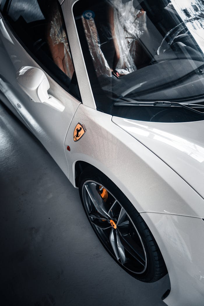 Elegant white sports car with sleek design and luxurious logo captured in Kyoto, Japan.