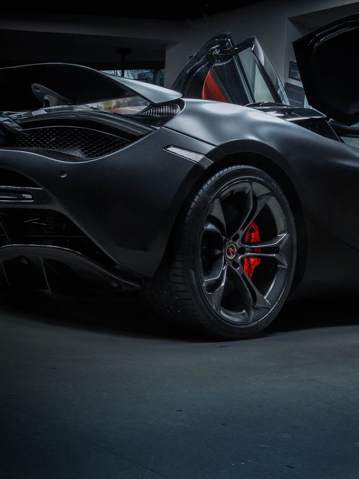A stunning black luxury sports car showcased with open doors in an Ankara garage setting.